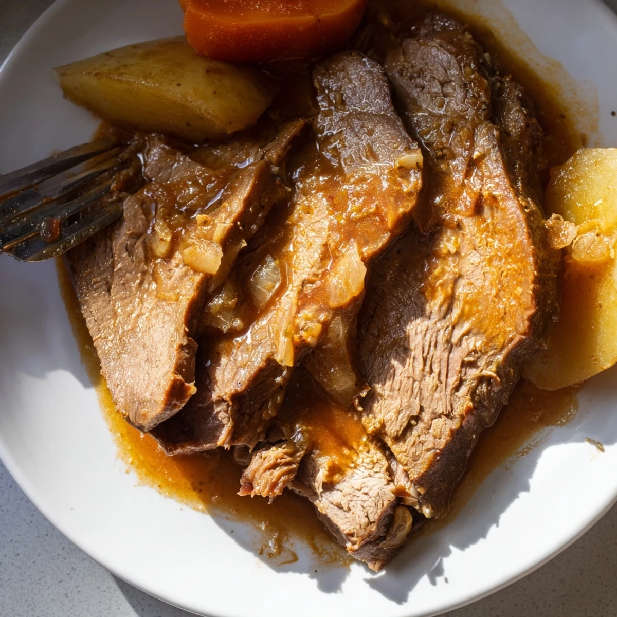 Hearty Slow Cooker Pot Roast with Carrots and Potatoes plated with roasted vegetables for a family dinner.