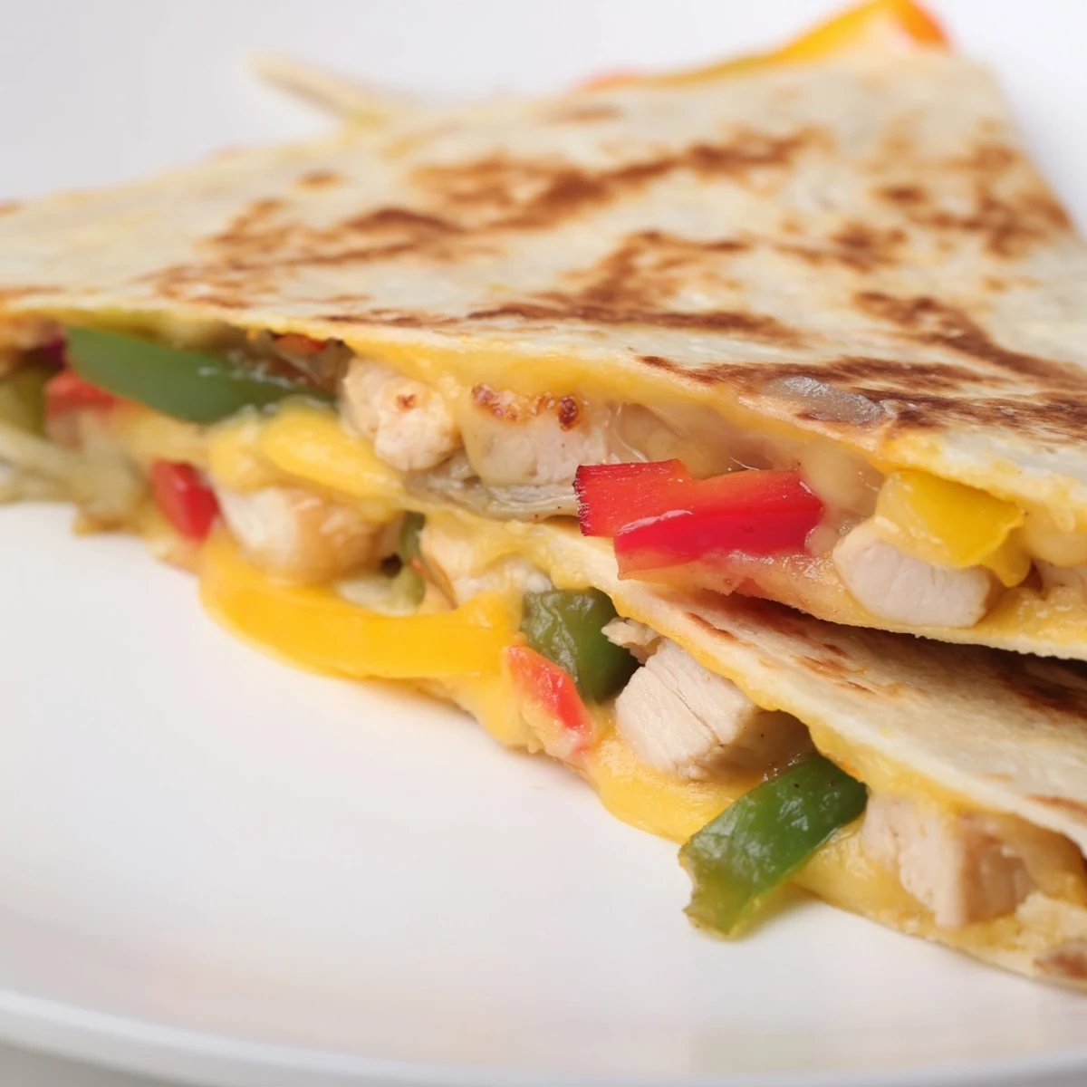 Golden-brown Chicken Quesadillas with Peppers and Onions on a rustic board, served with salsa and guacamole.