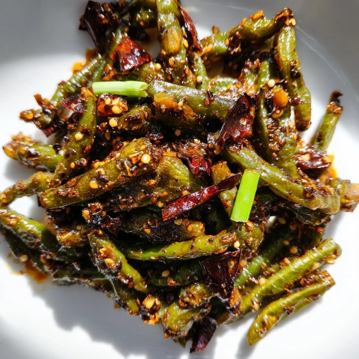 Stir-fried Spicy Szechuan Green Beans with blistered skin and a fiery red chili bean sauce.