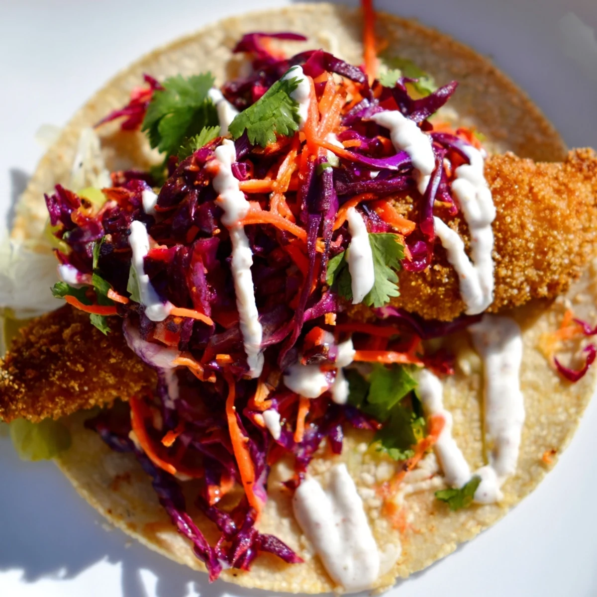Crispy Fish Tacos with Cabbage Slaw and Lime Crema stacked with golden fish and zesty drizzle.