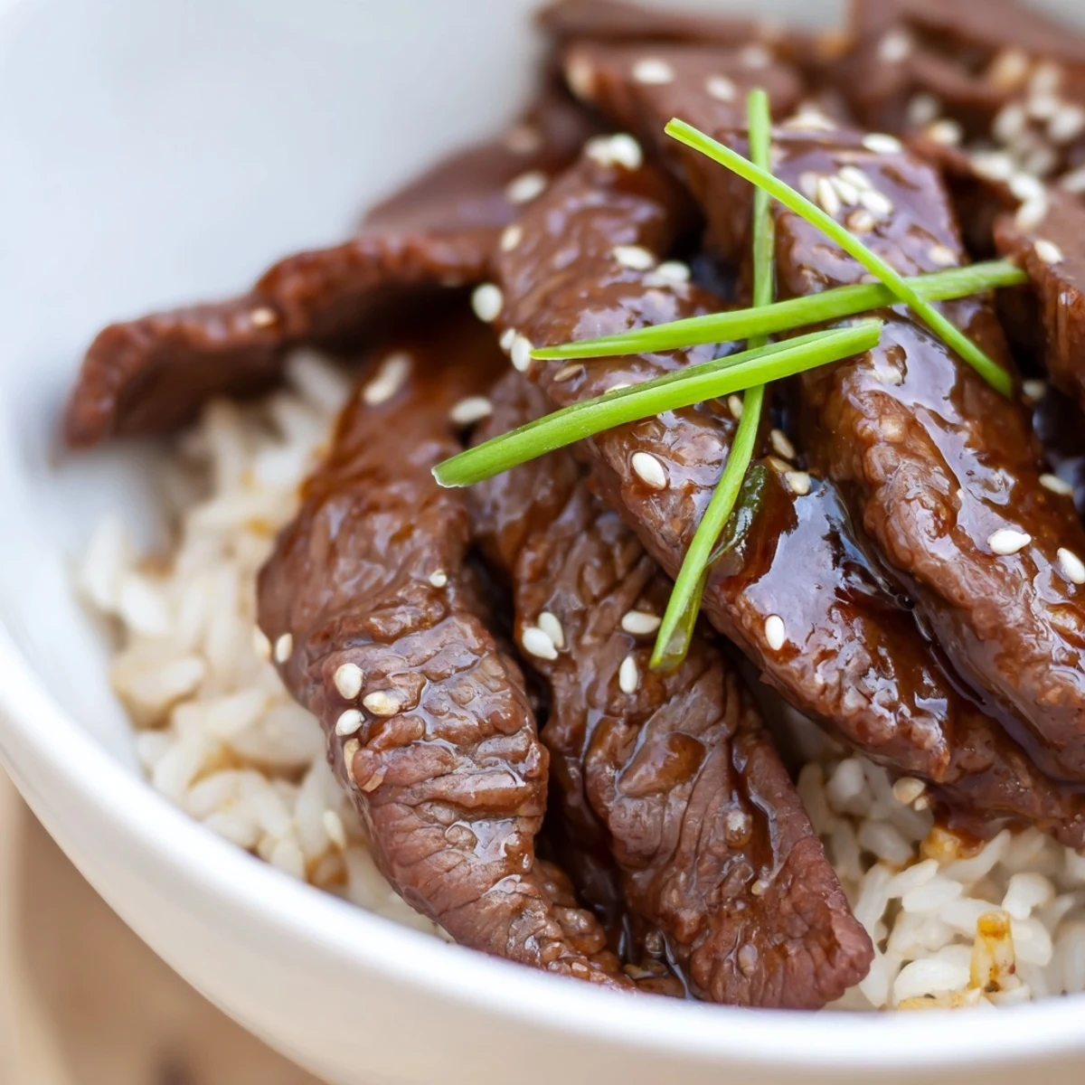 Garnished with green onions and sesame seeds, this comforting Beef Bowl with Steamed Rice looks delicious.