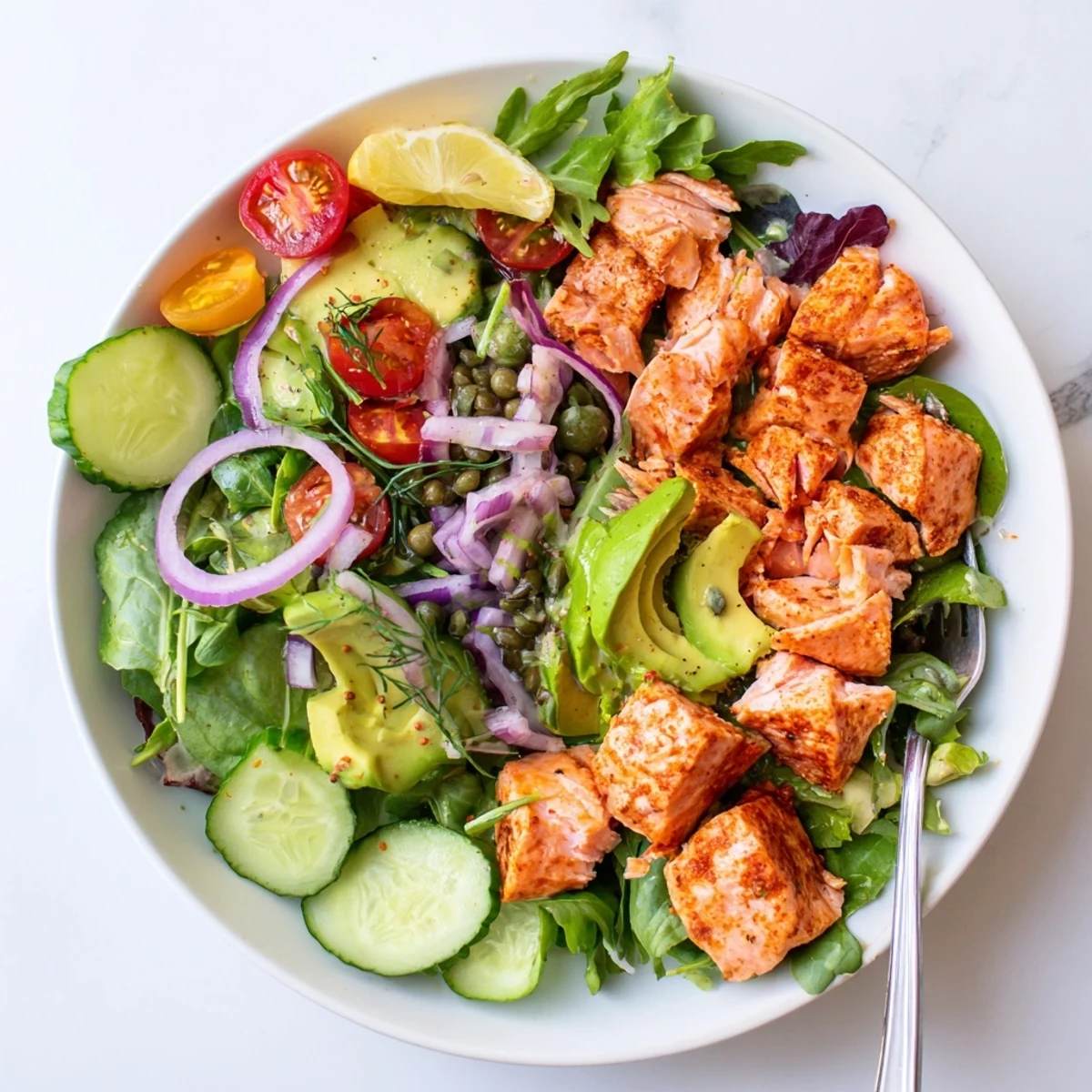 Freshly prepared Baked Salmon Lunch Salad garnished with lemon wedges and dill, ready to serve for a healthy gluten-free lunch.