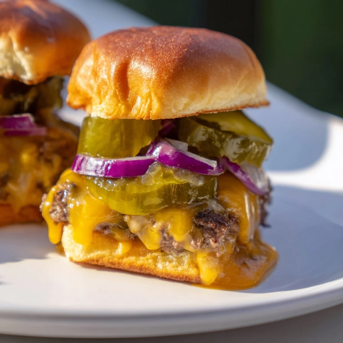 Backyard barbecue platter of Tailgate Burger Sliders with Pickles ready for serving.