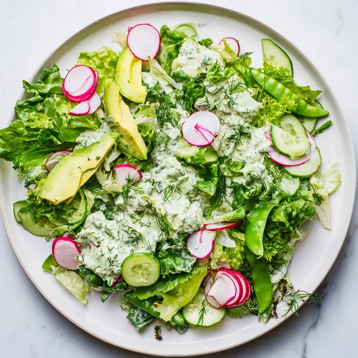 Freshly made Green Salad with Green Goddess Dressing, featuring crisp romaine, butter lettuce, and creamy avocado slices.