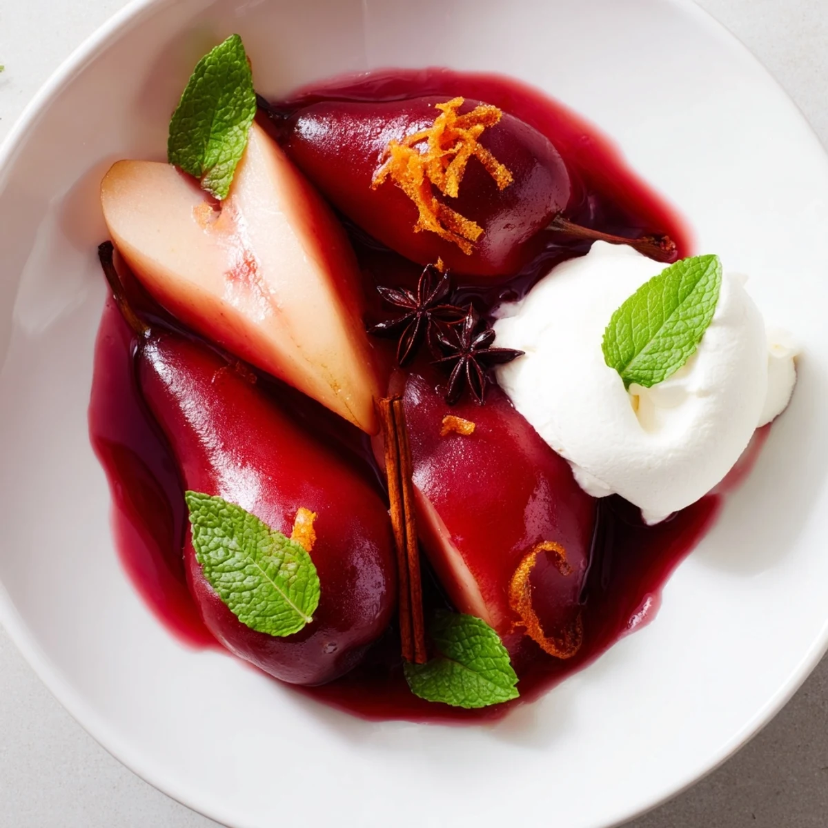 Poached pears in grape juice, served in a shallow bowl with a delicate swirl of whipped cream.
