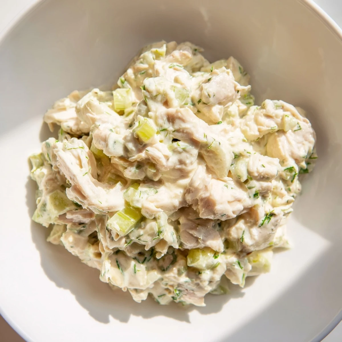 A bowl of creamy remoulade sauce studded with sweet, lump crab meat, garnished with fresh parsley and served with crackers.
