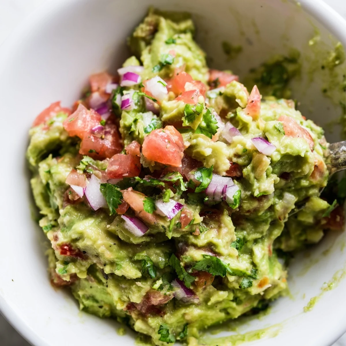 A vibrant Mexican dip of guacamole and pico de gallo, ready to be scooped up with crispy tortilla chips.