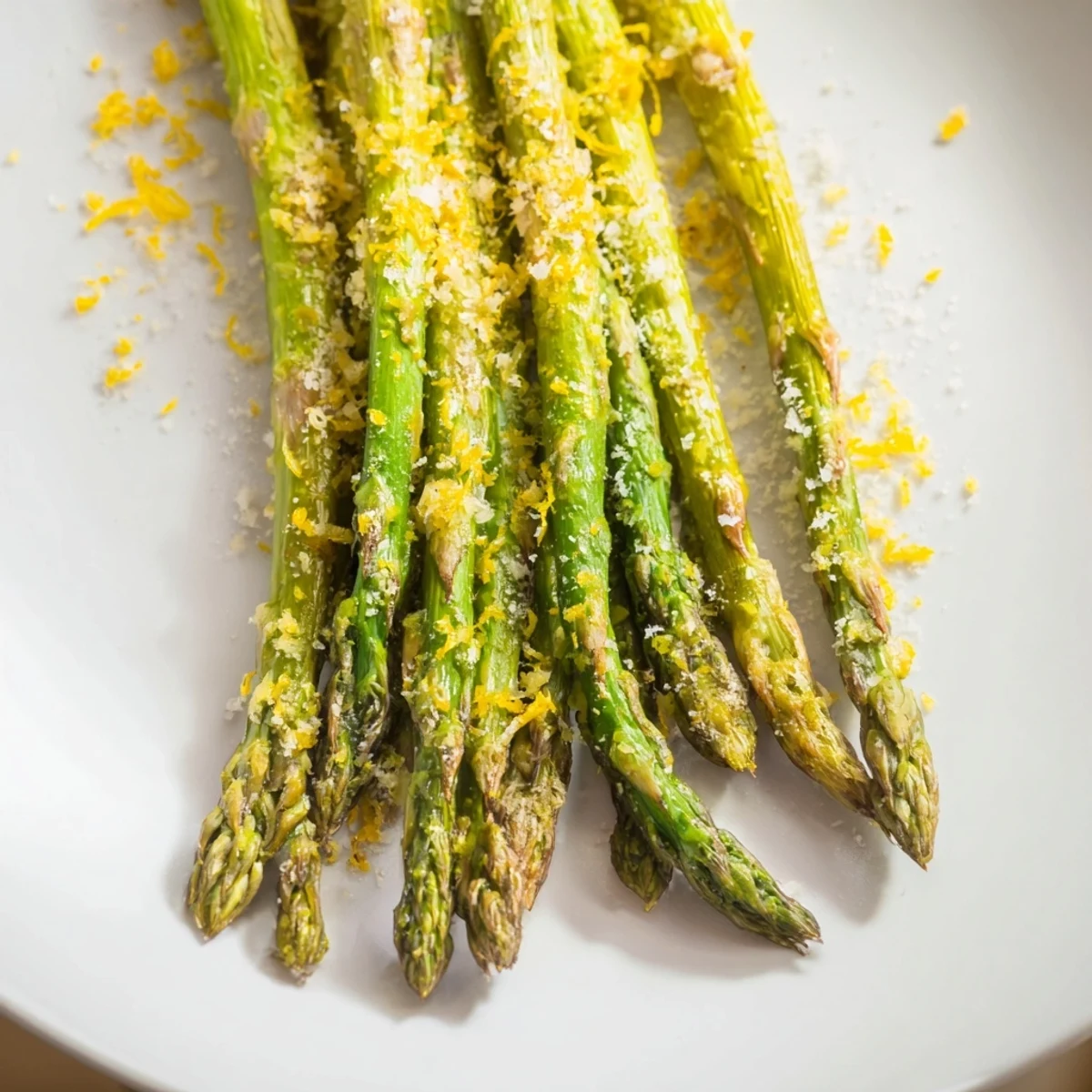 Tender roasted asparagus with Parmesan and lemon, served hot on a rustic plate.