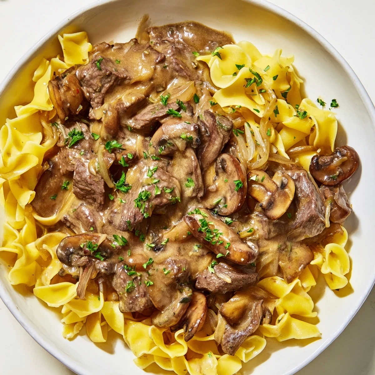 Tender beef strips and creamy mushroom sauce in Beef Stroganoff with Mushroom Gravy over fluffy noodles.