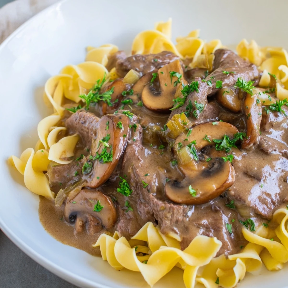 A rustic skillet of Beef Stroganoff with Mushroom Gravy, featuring savory mushrooms and sour cream sauce.