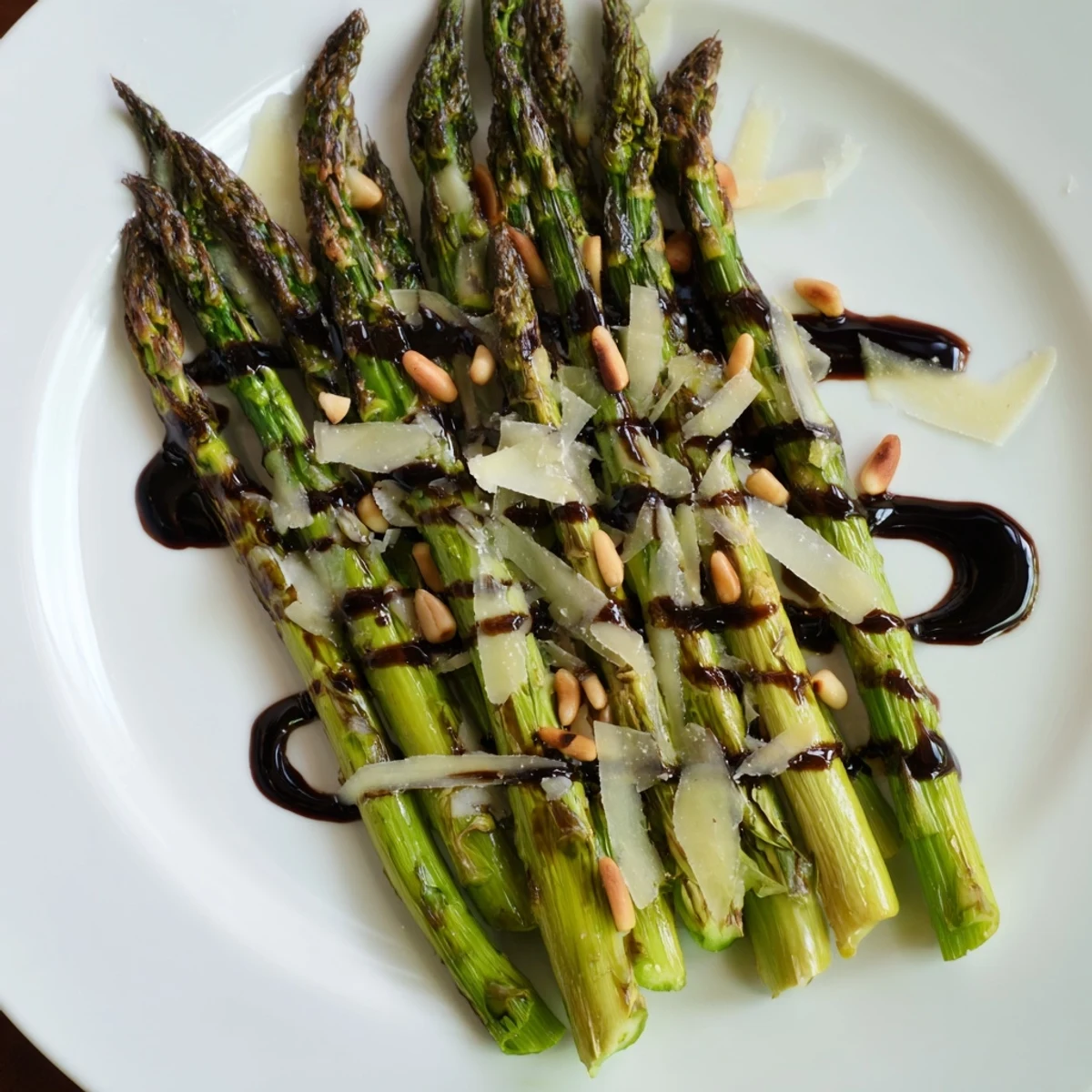 Roasted asparagus with balsamic glaze served warm, drizzled sweet-tangy sauce, perfect vegetarian side for dinner.
