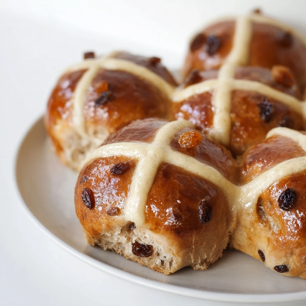 Warmly glazed Easter Hot Cross Buns fresh from the oven, their sweet cross baked to perfection.