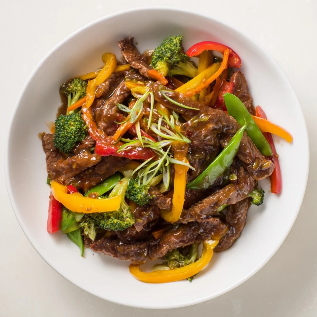 Spicy Beef Stir Fry with Mixed Vegetables sizzling in a wok with carrots, bell peppers, and snap peas.