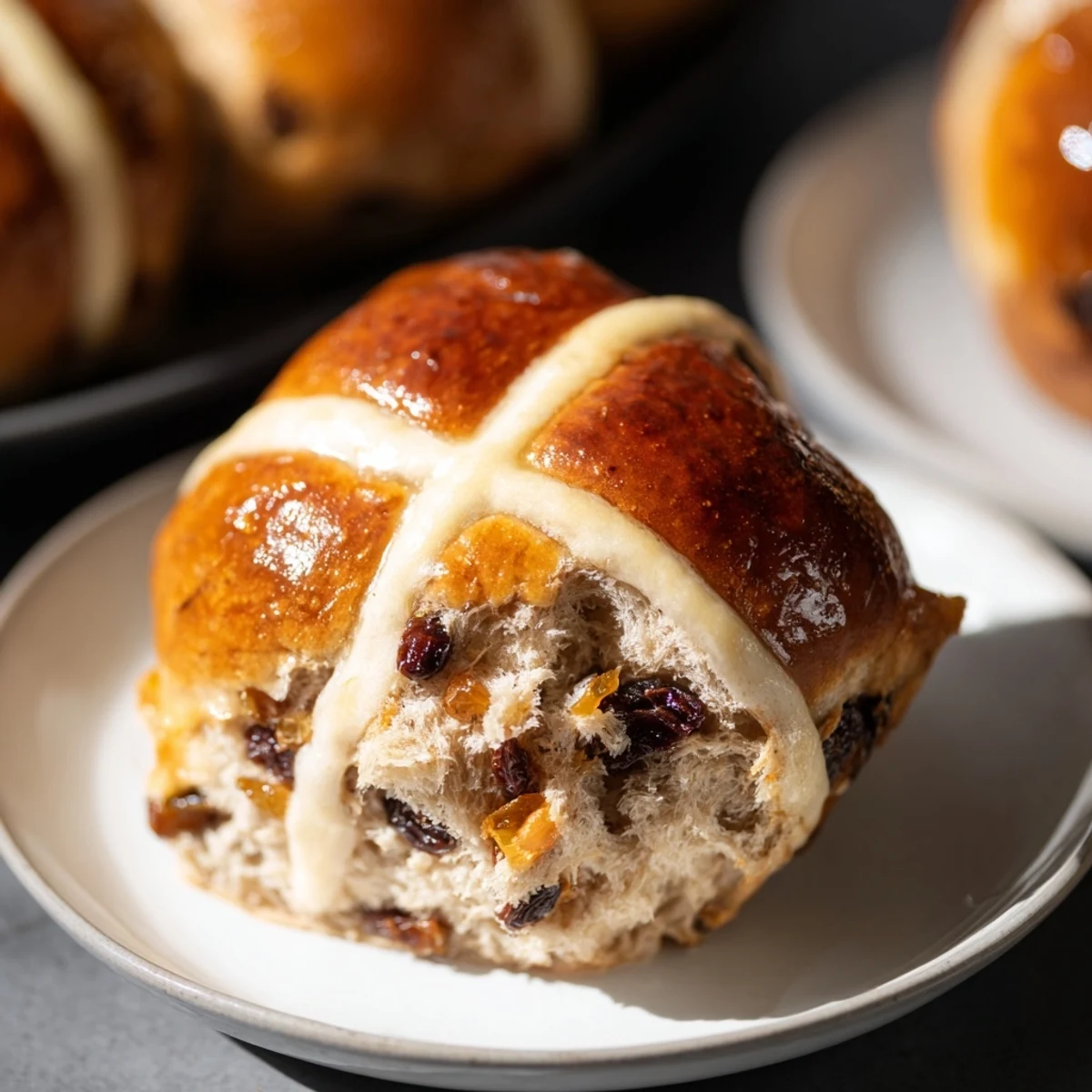 Warm Easter Hot Cross Buns with spices and dried fruit, ready to serve with butter and tea.