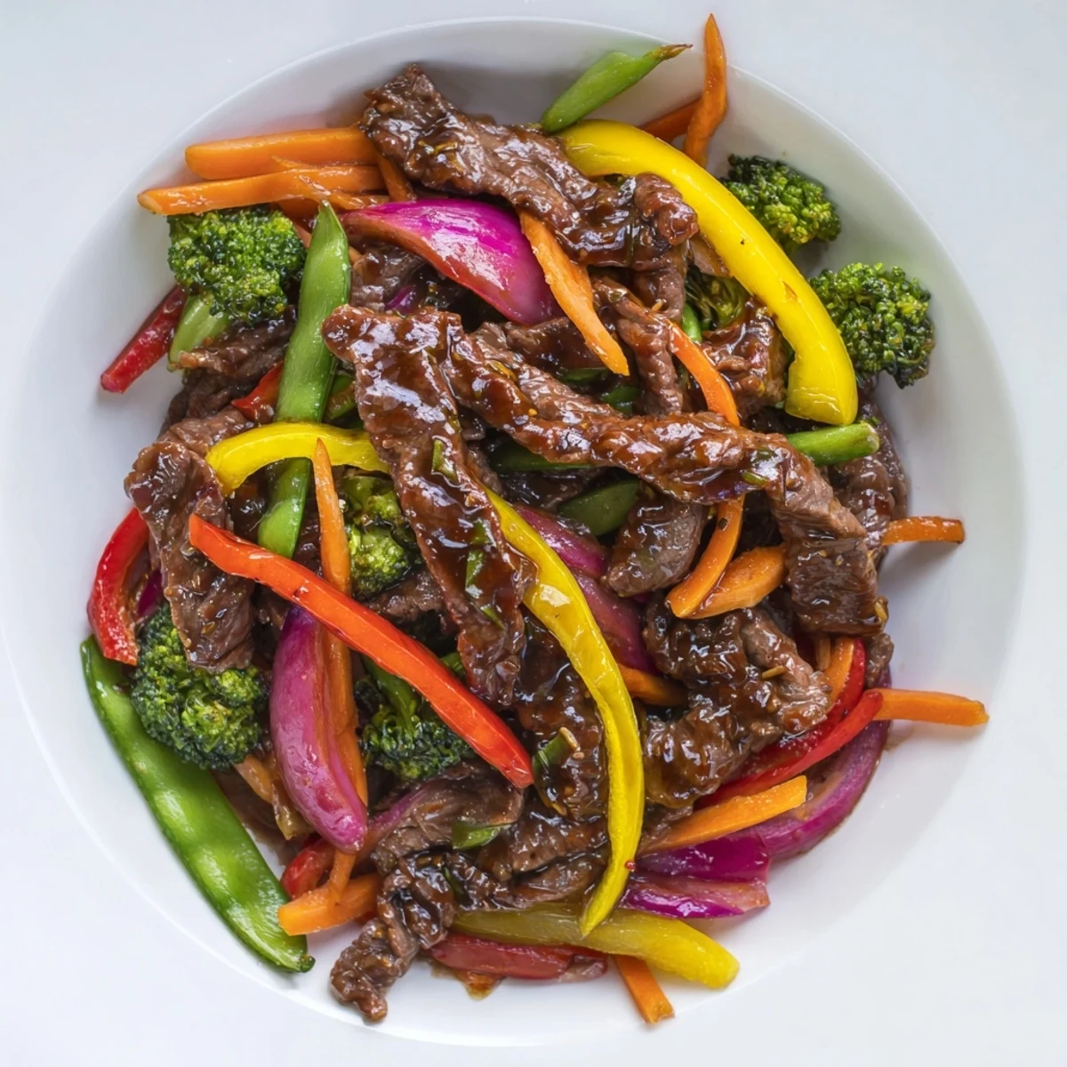 A close-up photo of Spicy Beef Stir Fry with Mixed Vegetables in a wok, featuring saucy beef strips, crisp broccoli, and vibrant bell peppers.