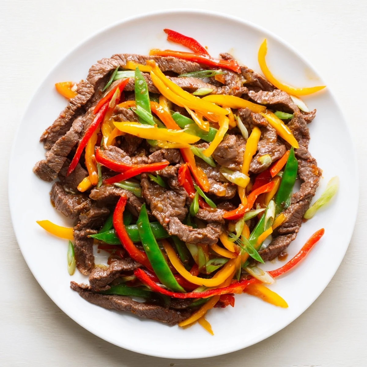 Sizzling Spicy Beef Stir Fry with Vegetables in a hot wok, colorful peppers and snap peas glistening with sauce.