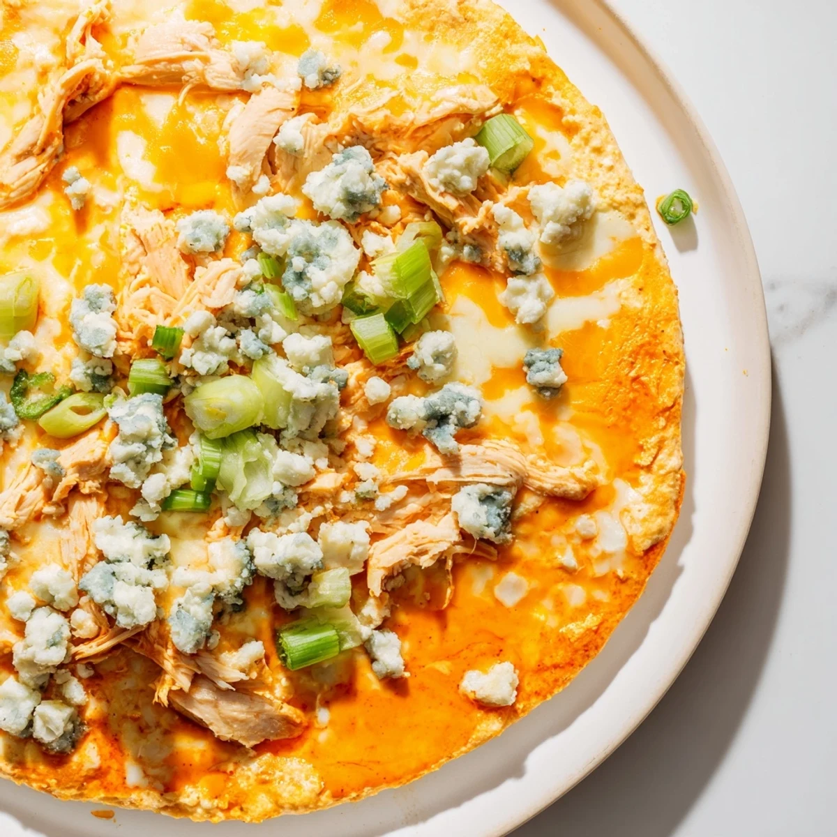 Bubbling Keto Buffalo Chicken Dip fresh from the oven with blue cheese garnish.