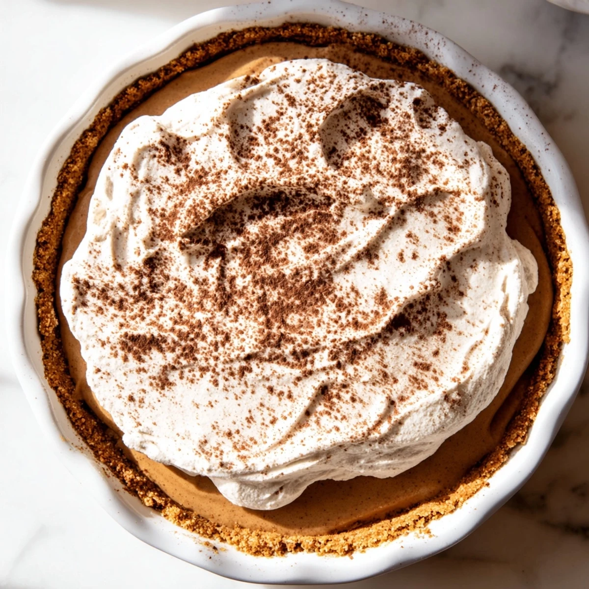 Rich Keto Cold Brew Coffee Pie topped with fluffy whipped cream and garnished with whole coffee beans.