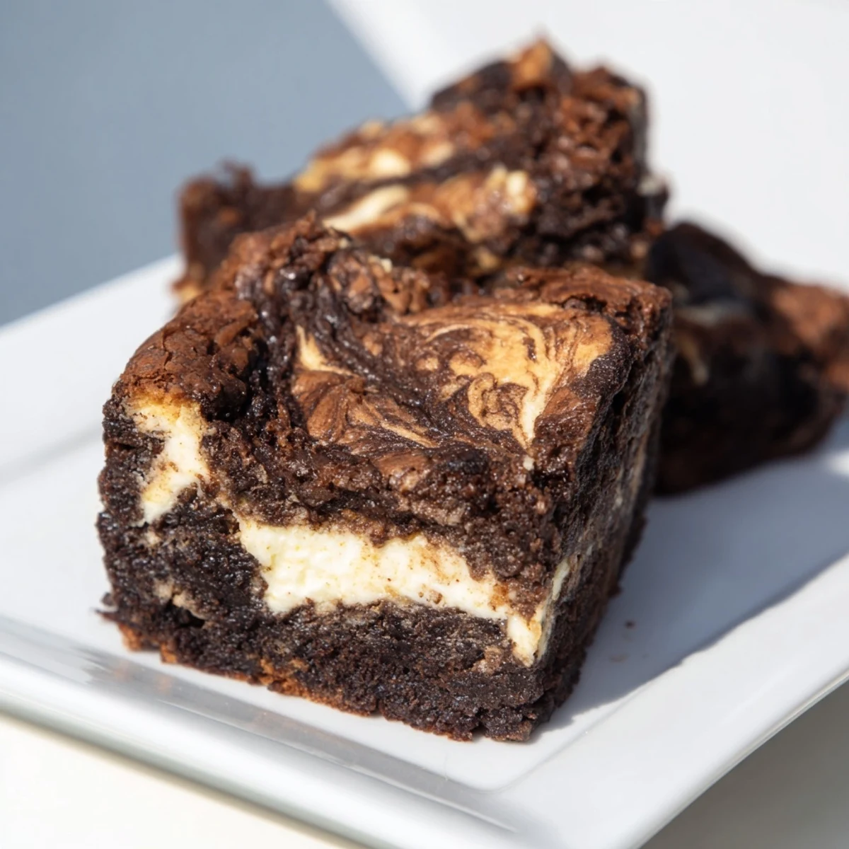A close-up slice of Cottage Cheese Brownies revealing a moist crumb and tangy cottage cheese marbling on a marble board.