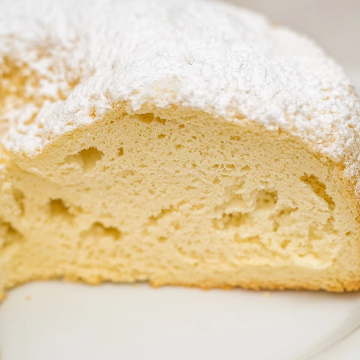 Fluffy Yogurt Cloud Cake on a wire rack, garnished with fresh berries and a dollop of whipped cream.