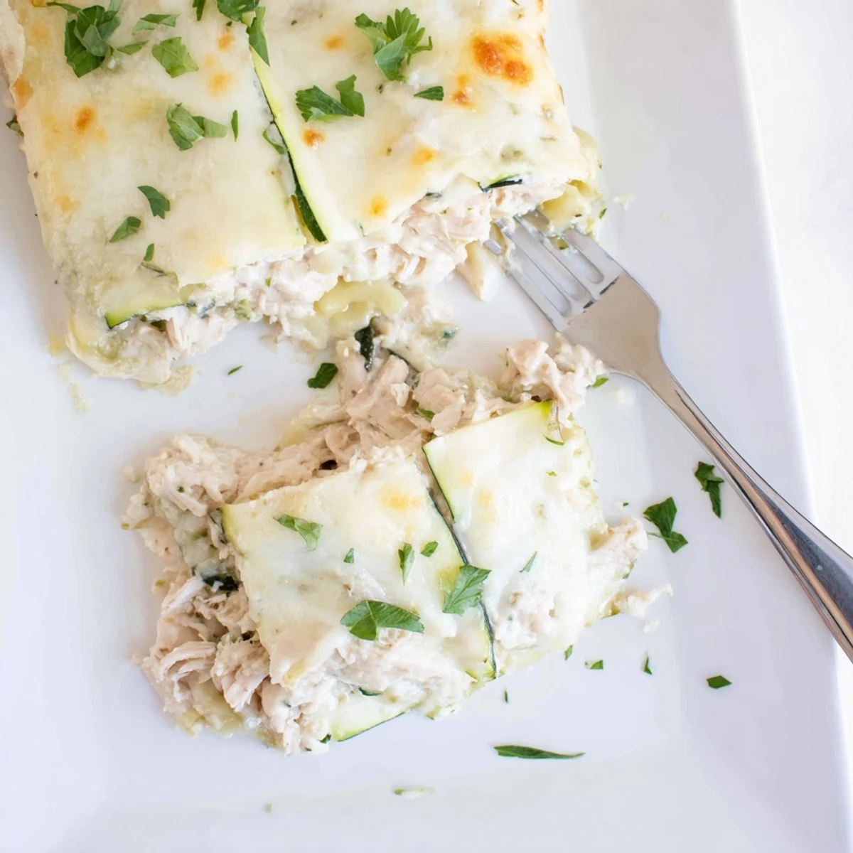 A close-up of Chicken Alfredo Zucchini Lasagna shows melted mozzarella and rich sauce, perfect for a comforting low-carb dinner.