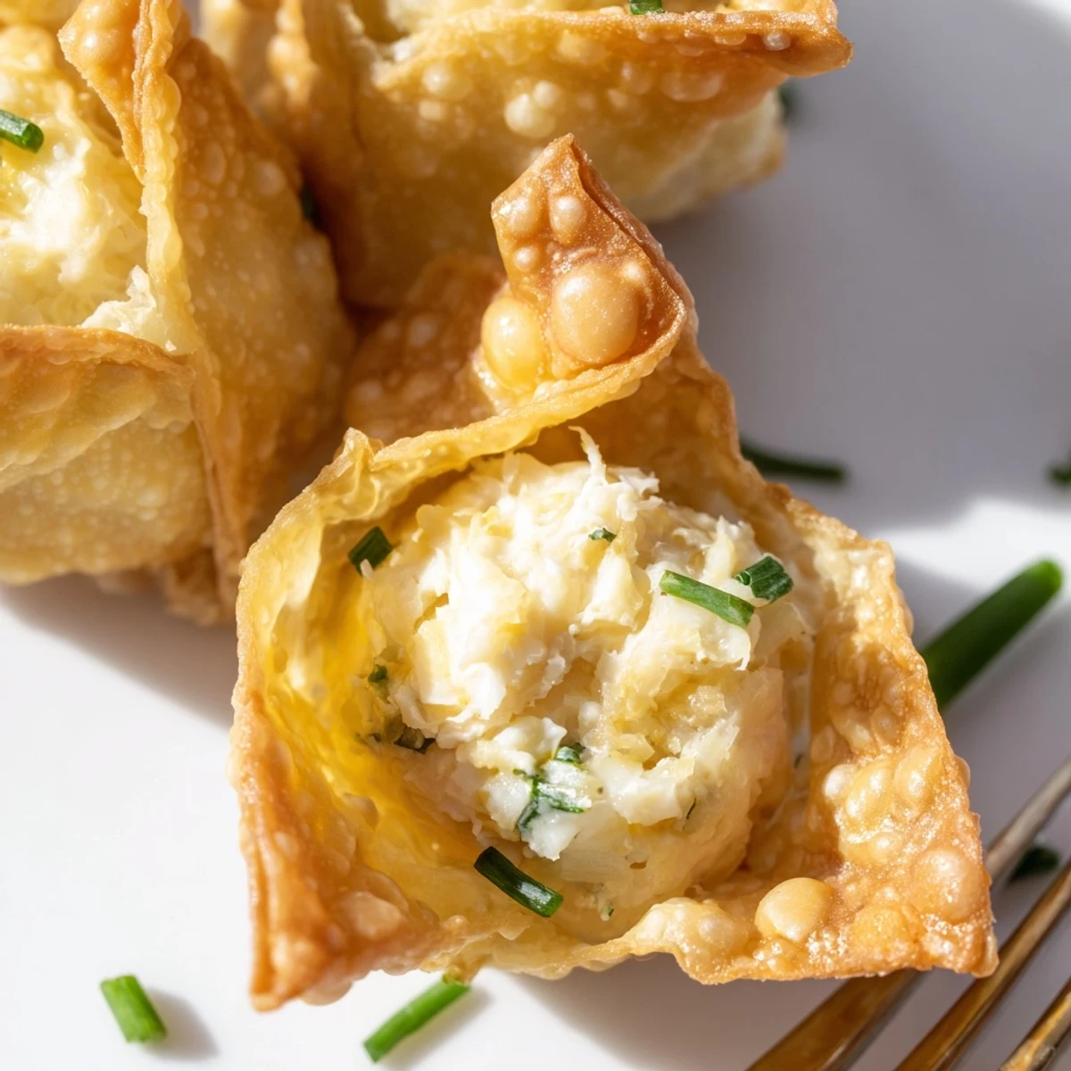 Golden fried Crispy Crab Rangoon Bombs with a creamy filling, served warm with sweet chili dipping sauce on a plate.