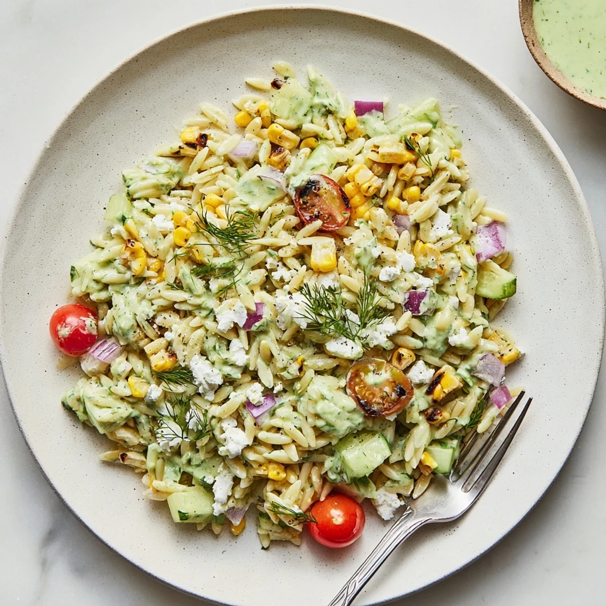 Close-up view of Grilled Corn Orzo Salad with Scallion Dill Dressing showcasing tender pasta, diced vegetables, and a zesty vinaigrette ready to serve.
