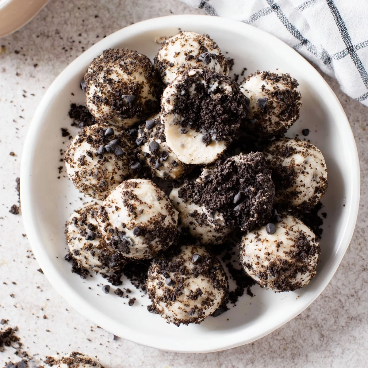 Cream Cheese Oreo Protein Balls drizzled with melted chocolate and served on a tray.