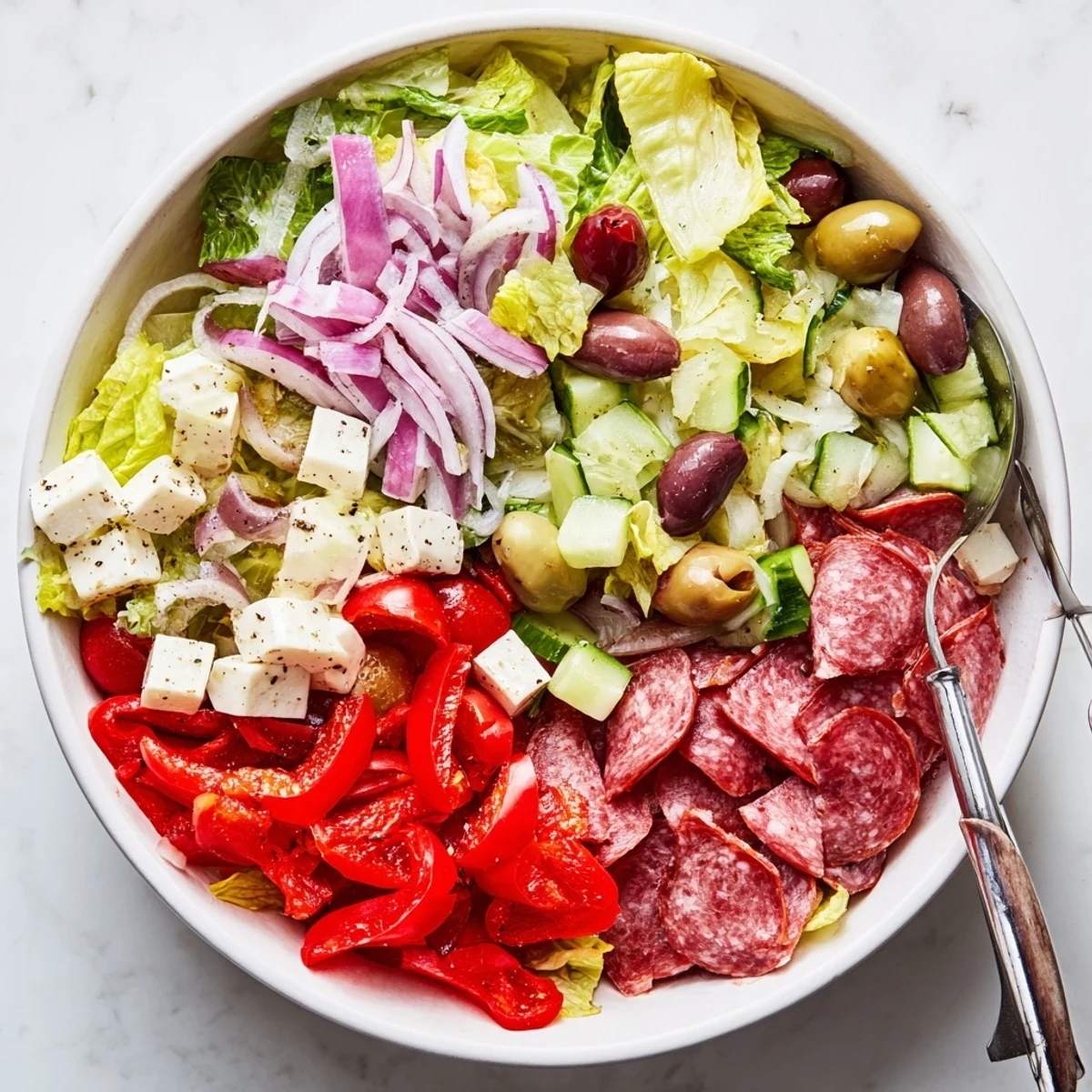 Vibrant bowl of Italian chopped salad featuring crisp vegetables, cheese, and zesty homemade Italian dressing