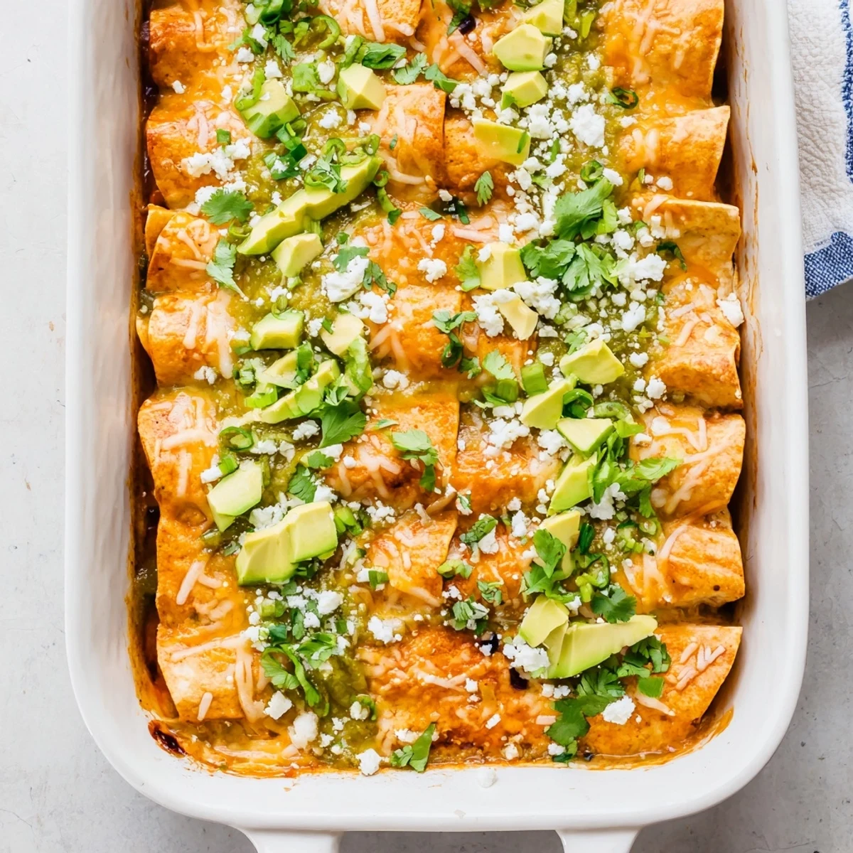 Oven-baked salsa verde chicken enchiladas featuring tender shredded chicken wrapped in corn tortillas with tangy green sauce
