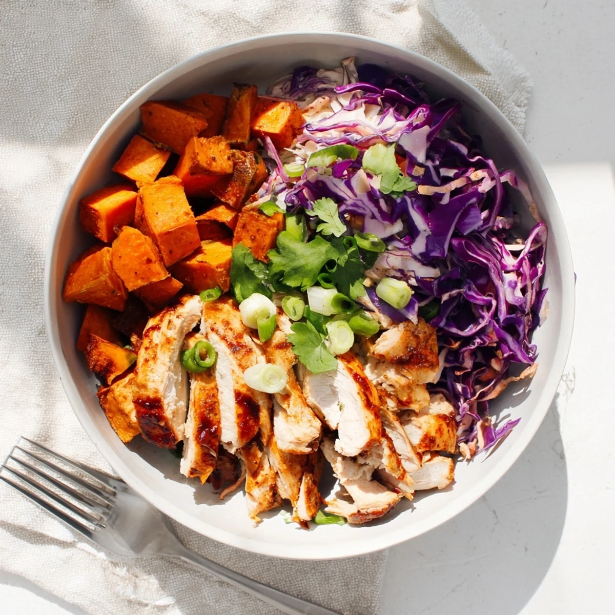 Flavor-packed meal prep bowl with juicy BBQ chicken sweet potatoes and creamy coleslaw garnished with cilantro