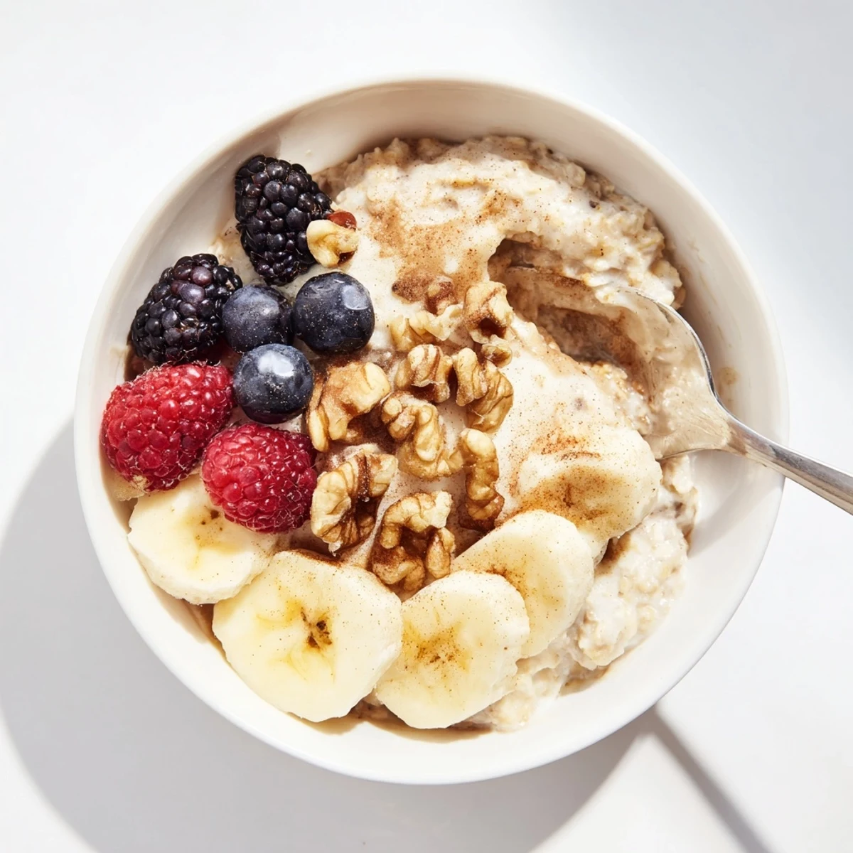 Glass jar filled with creamy brown sugar overnight oats topped with fresh banana slices and crunchy walnuts
