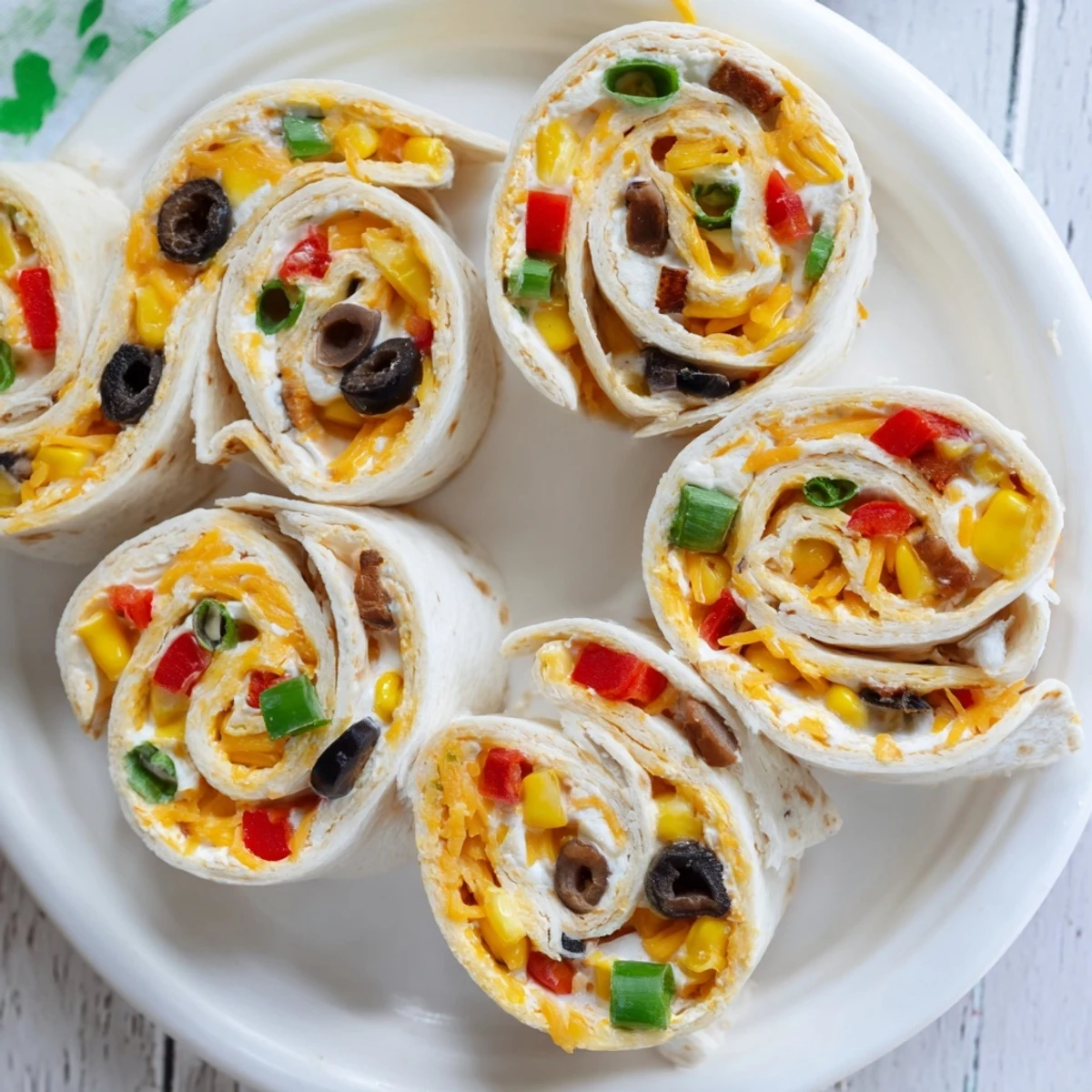 Colorful spiral of Taco Cream Cheese Pinwheels on a white serving platter