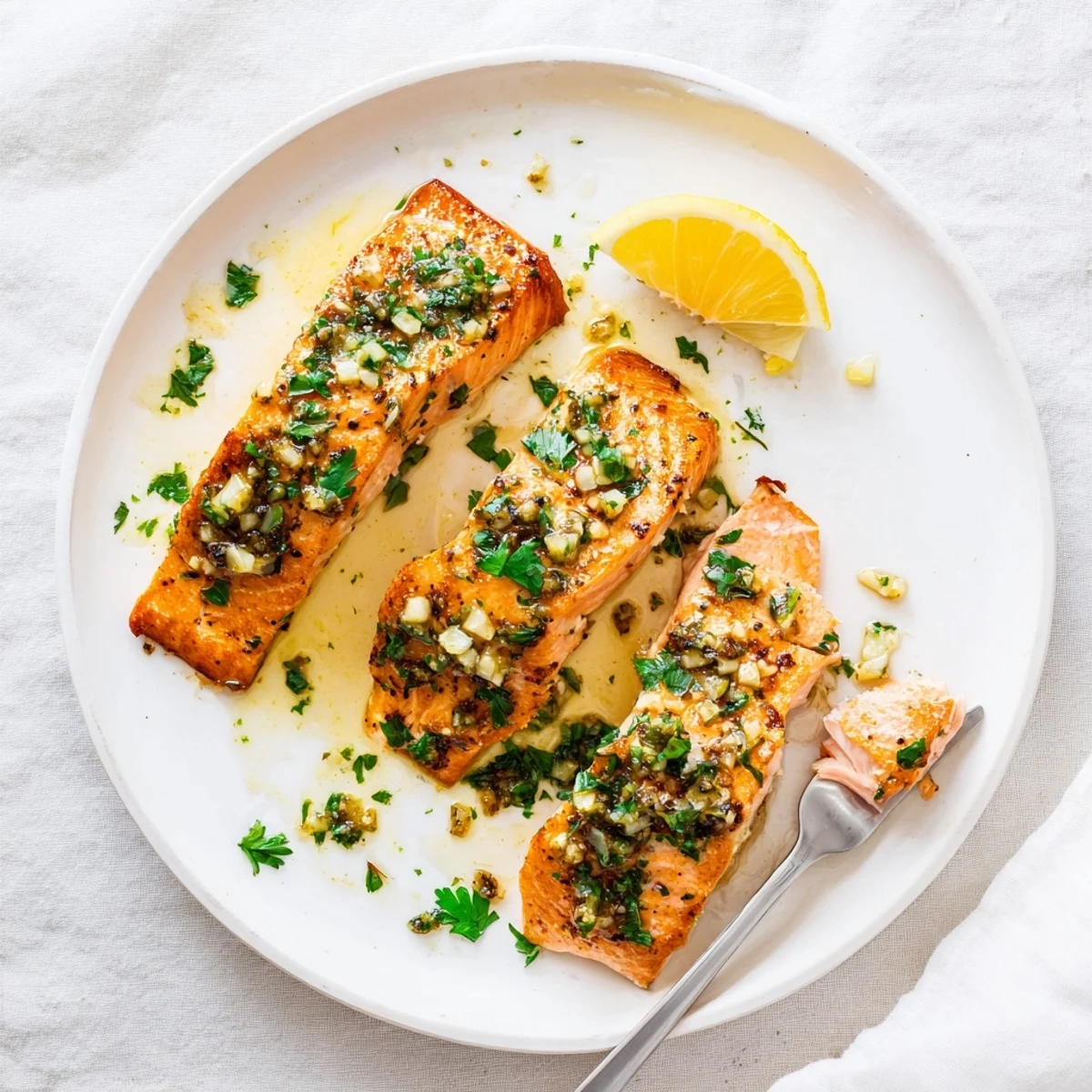 Perfectly cooked salmon with golden exterior drizzled with fragrant garlic butter and lemon zest