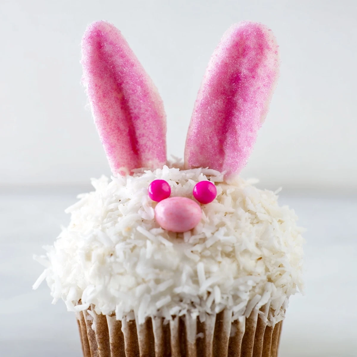 Adorable spring bunny cupcakes featuring buttercream frosting, shredded coconut coating, and cute face decorations