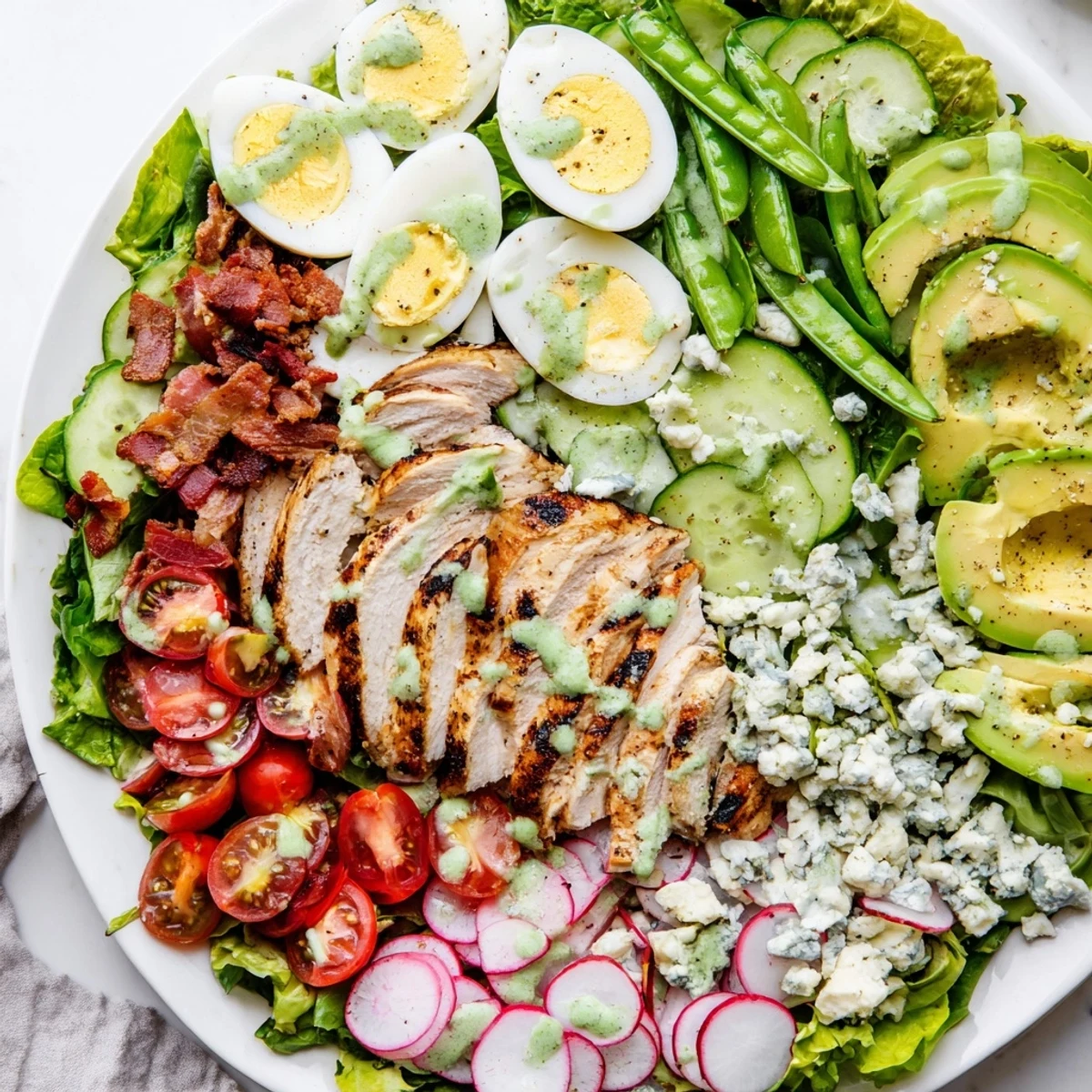 Fresh Spring Cobb Salad plate featuring juicy chicken, hard-boiled eggs, bacon, radishes, and creamy blue cheese on spring greens