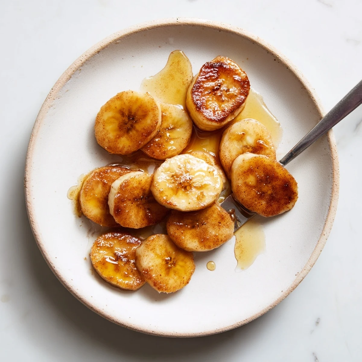Golden pan fried cinnamon bananas caramelized in butter with melting brown sugar