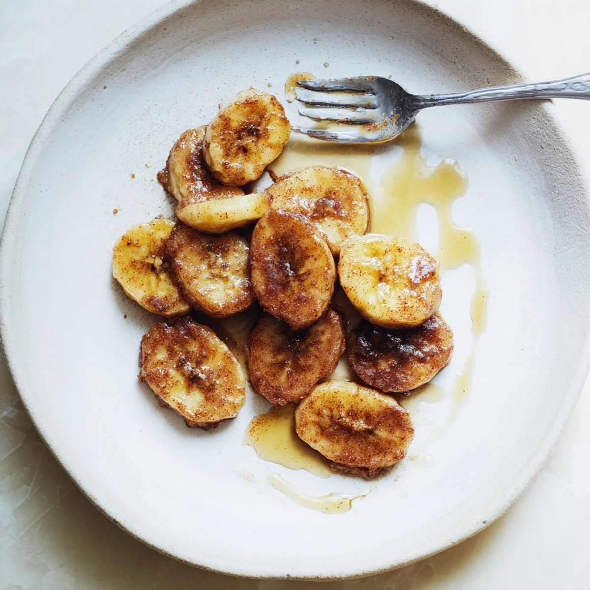 Warm skillet of caramelized pan fried cinnamon bananas served with optional honey drizzle