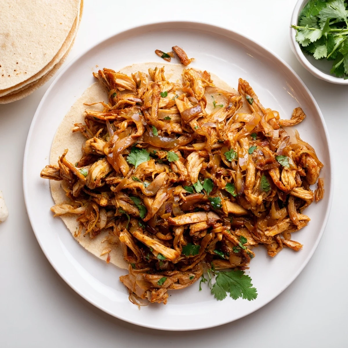Baked oyster mushroom carnitas sizzling on a baking sheet with caramelized edges and smoky spices