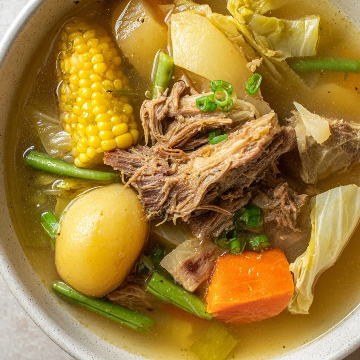 Filipino Bulalo beef shank soup served with corn cabbage and rich clear broth