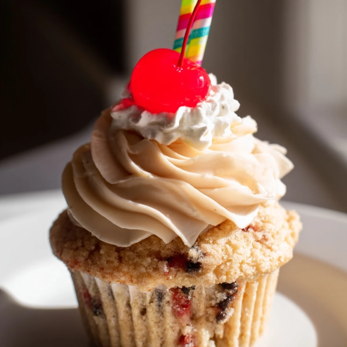 Homemade banana milkshake cupcakes with fluffy buttercream swirls and decorative paper straws for serving