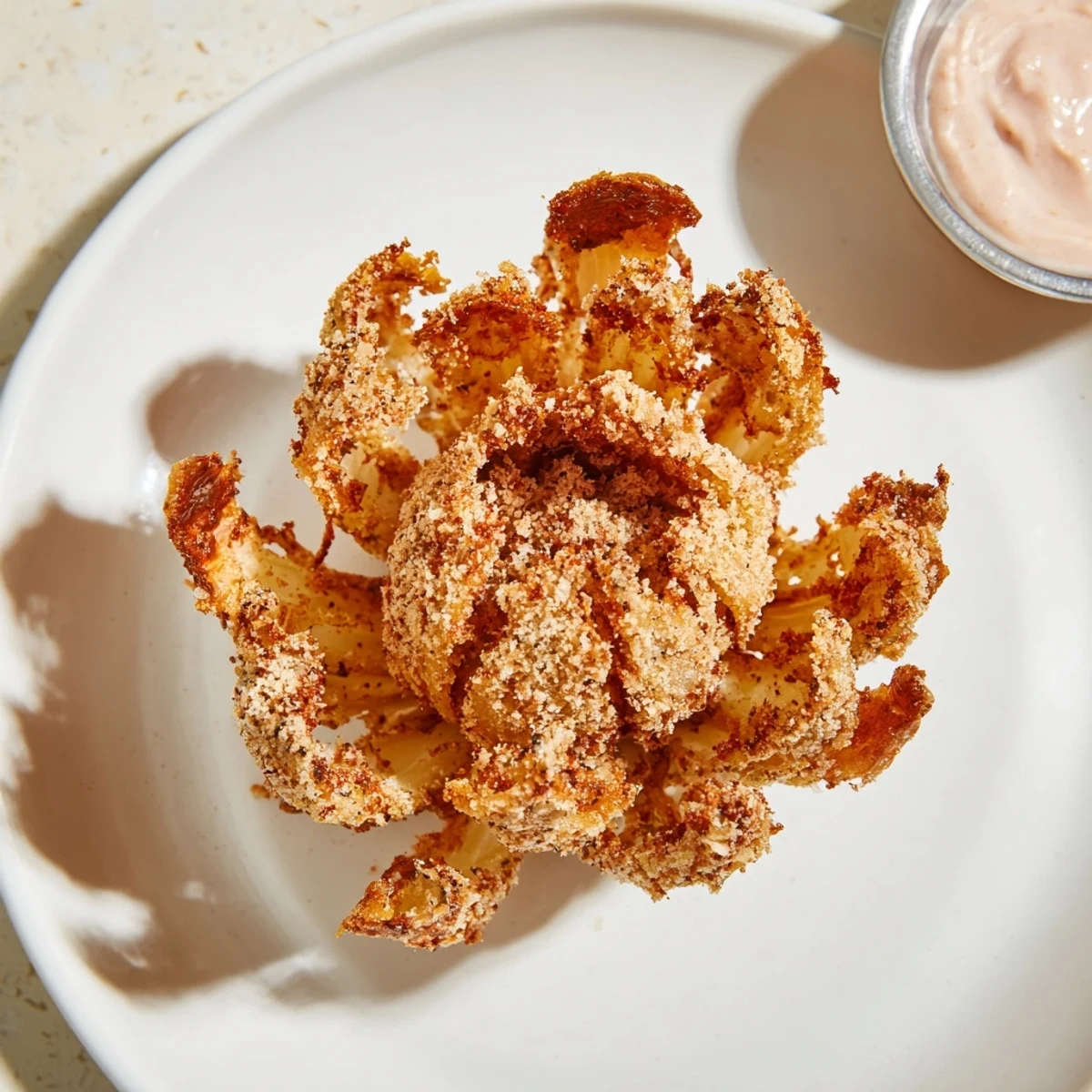 Deep-fried mini bloomin onions with separated crunchy petals and a side of creamy ranch