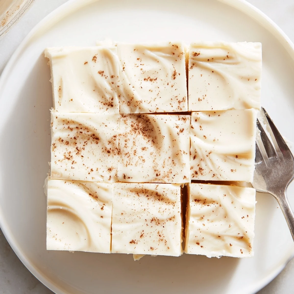 Velvety Eggnog Fudge studded with chopped pecans, resting on a cooling rack