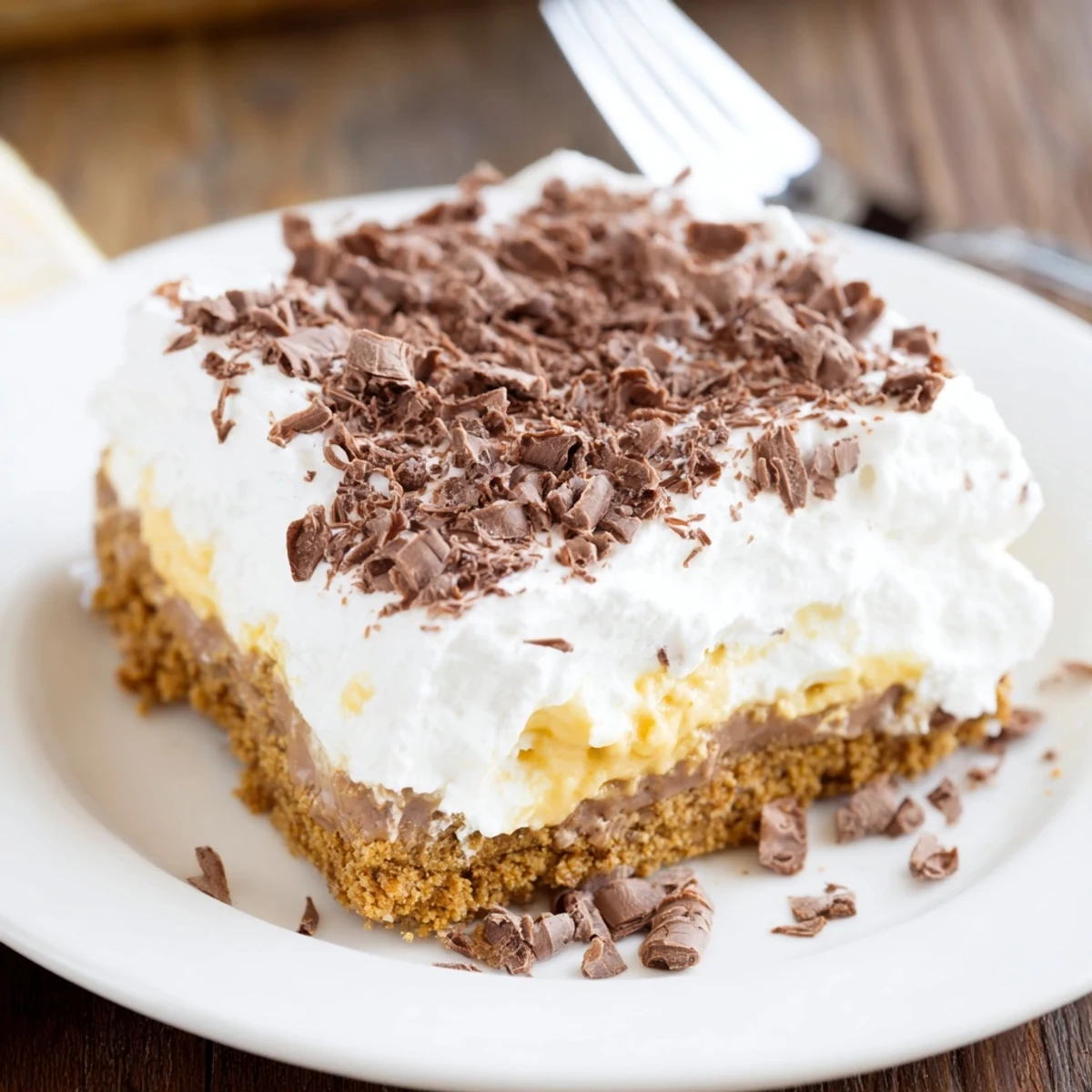 No Bake Layered Dessert with creamy vanilla pudding, graham crust and chocolate shavings