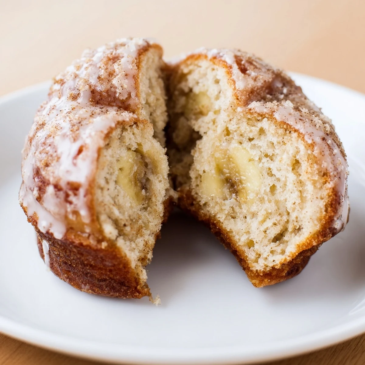 Plate of glazed Banana Donuts beside a steaming cup of coffee