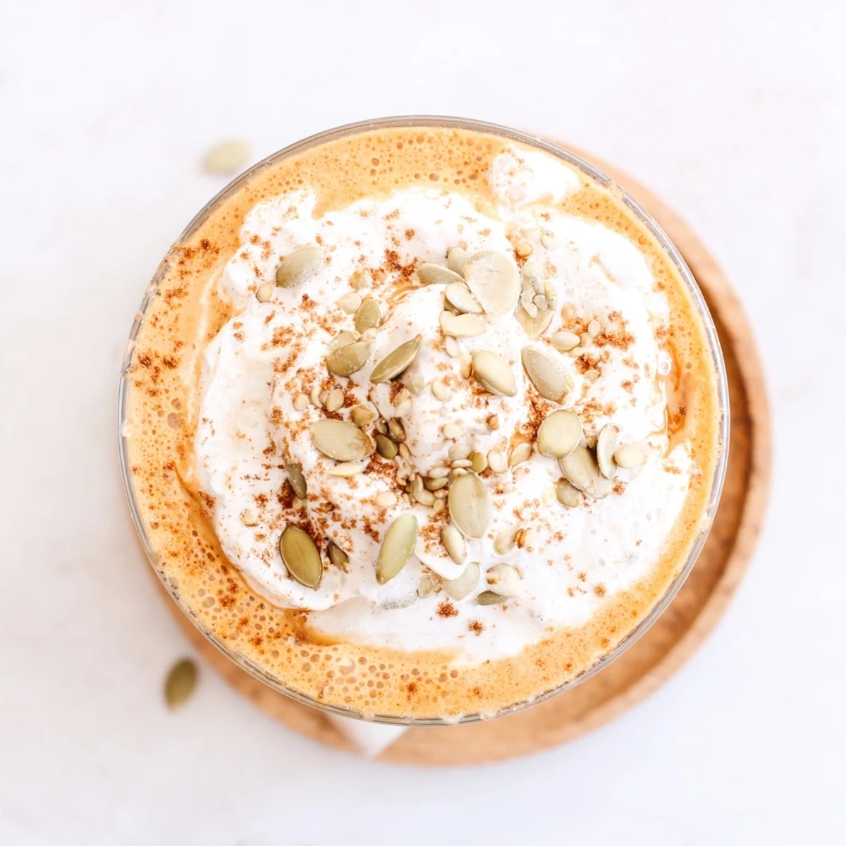 Silky pumpkin chia delight drink sprinkled with cinnamon in a clear glass showing layered texture
