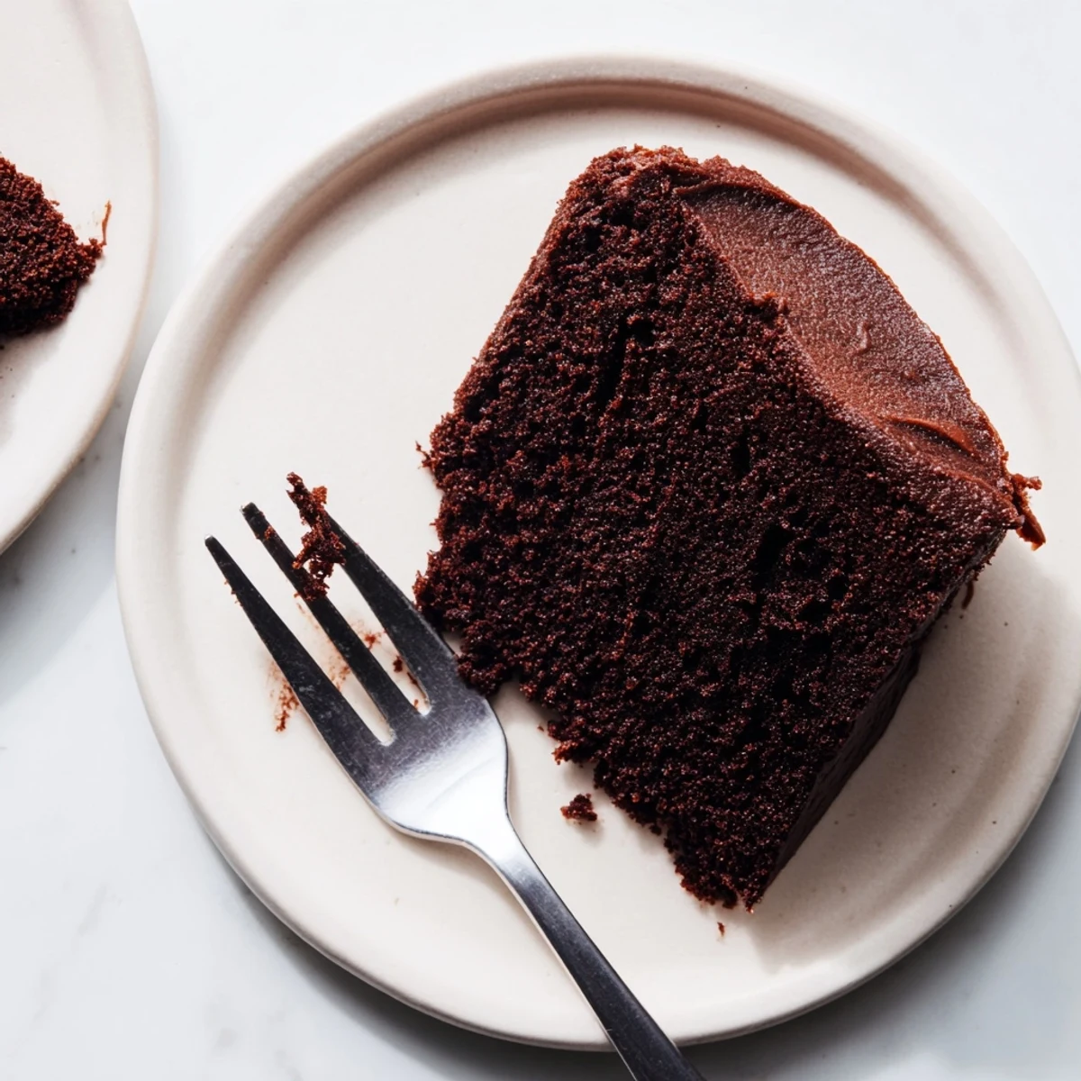 Slice of moist chocolate mayonnaise cake revealing irresistibly tender texture beneath creamy frosting