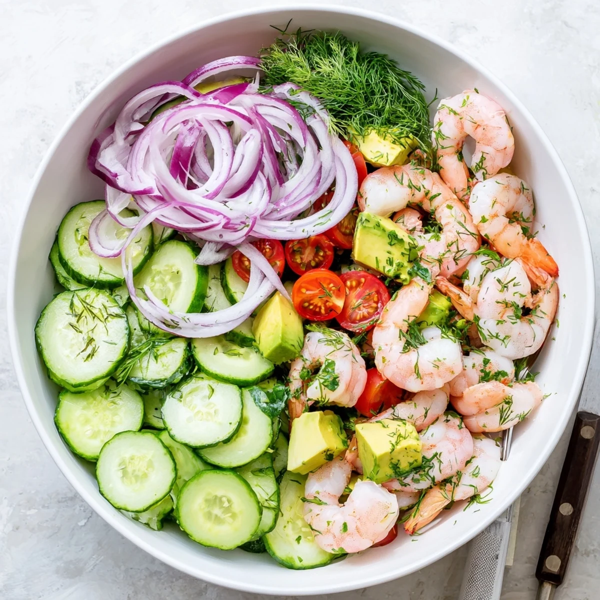 Fresh cucumber shrimp salad bowl featuring succulent pink shrimp with crisp sliced vegetables and zesty citrus dressing
