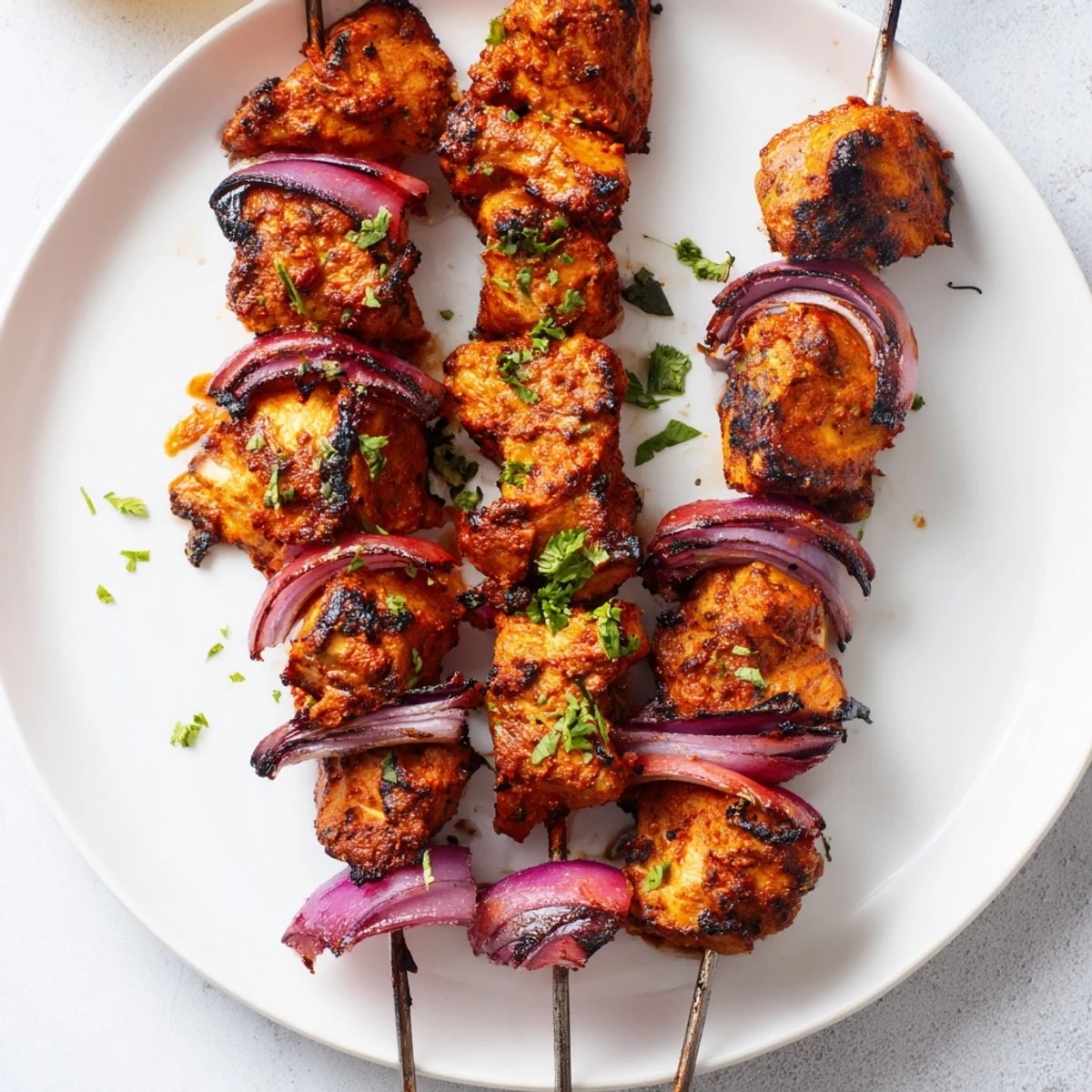 Grilled Tandoori Chicken Tikka Skewers basted with ghee, served with mint chutney