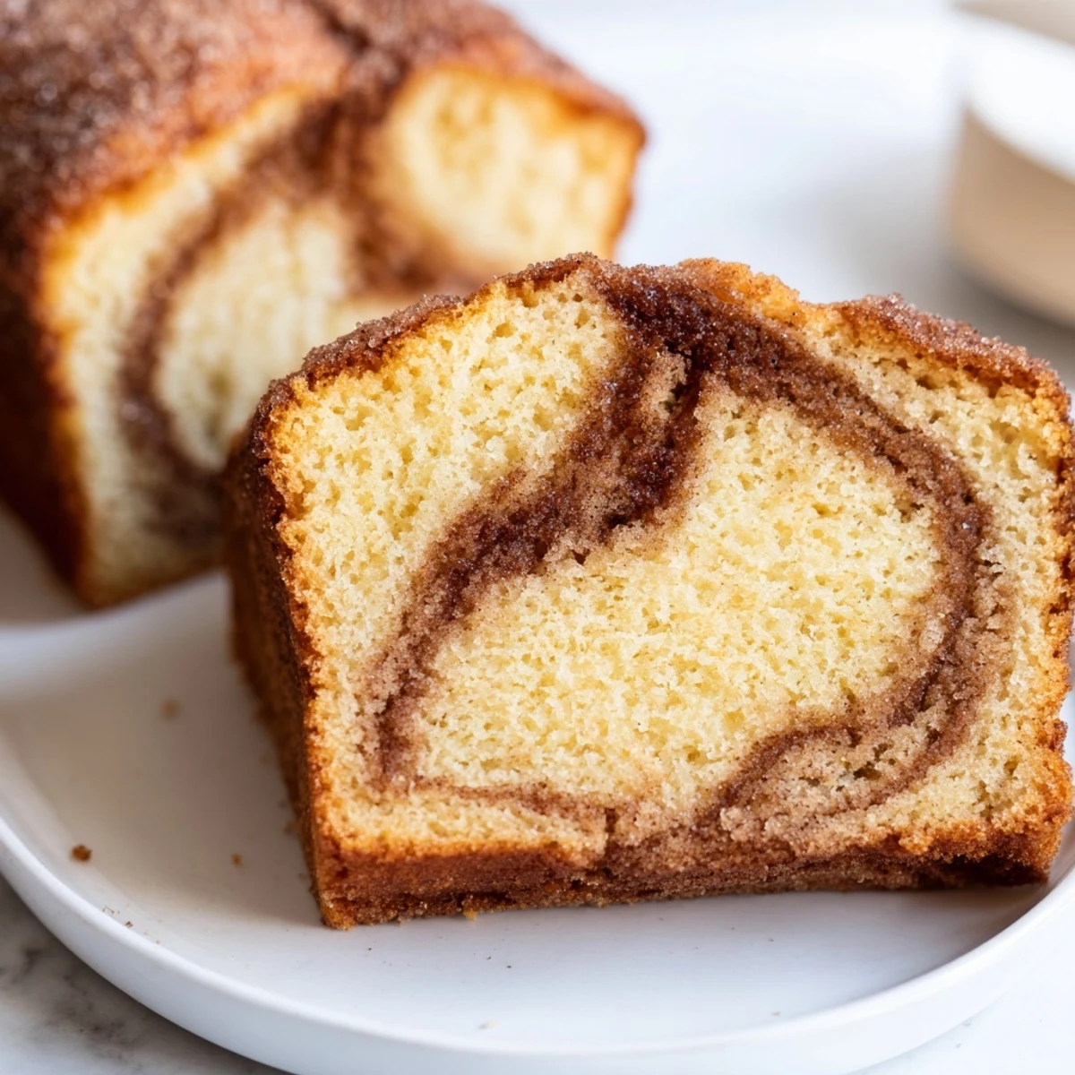 Warm cinnamon donut loaf sliced on a rustic wooden cutting board